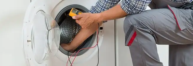 Dryer repair technician inspecting and repairing a clothes dryer in Columbia, MO