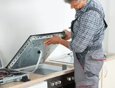 Appliance repair technician installing a built-in cooktop in Columbia, MO
