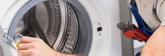 Appliance technician repairing a clothes dryer drum and internal parts in Columbia, MO