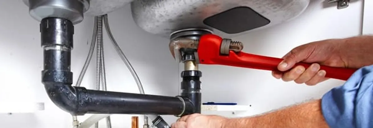 Garbage disposal repair technician tightening the sink drain and disposal connection in Columbia, MO