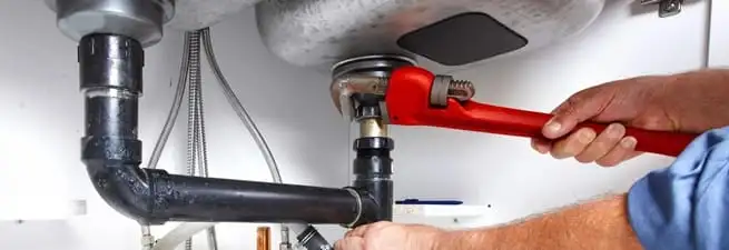 Garbage disposal repair technician tightening the sink drain and disposal connection in Columbia, MO