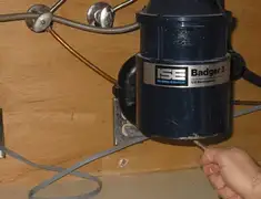 Garbage disposal repair technician tightening the mounting ring under a sink in Columbia, MO