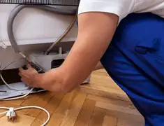 Appliance repair technician fixing refrigerator water line and connections in Columbia, MO