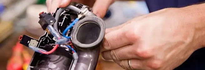 Vacuum repair technician reconnecting wiring and components in Columbia, MO