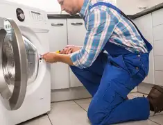Washing machine repair technician servicing a front-load washer in Columbia, MO