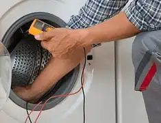 Washing machine repair technician testing a front-load washer with diagnostic tools in Columbia, MO