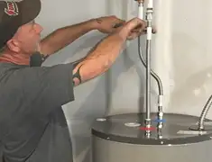 Water heater repair technician tightening supply line connections in Columbia, MO