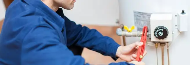 Water heater repair technician adjusting the temperature control and gas valve in Columbia, MO
